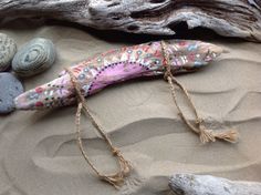 an odd shaped object sitting on top of sand next to rocks