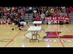 two people are performing tricks on a basketball court while an audience watches from the sidelines