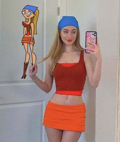 a woman in an orange skirt holding up a cell phone