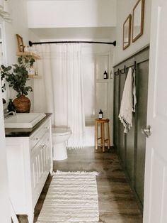 a bathroom with white walls and wooden floors