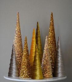 gold and silver christmas trees sitting on top of a white plate