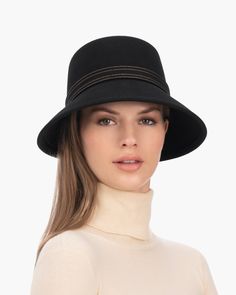 A fashionable women's cloche hat is hand-blocked of the finest superfelt, and then trimmed with a contrast stitch matching band of the same. The ultra sleek silhouette features a rakishly downturned brim, bringing focus to the eyes while framing the face beautifully. Brim span center front: 2.75"(7cm) side: 3"(7.5cm) Designed and finished in the USA Hand-blocked by skilled artisans Sustainable wool and cashmere blend superfelt Elasticized sweatband Adjustable head-size with hidden velcro® featur Elegant Wide Brim Cloche Hat For Fall, Elegant Wool Cloche Hat For Fall, Evening Felt Hat With Short Brim, Formal Brimmed Fedora, Elegant Flat Brim Cloche Hat For Fall, Elegant Fur Felt Cloche Hat, Fall Wide Brim Fur Felt Cloche Hat, Fall Cloche Hat With Short Brim In Fur Felt, Fur Felt Cloche Hat With Short Brim For Fall