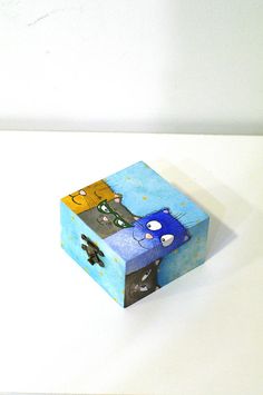 a blue and white box with two cats on it's sides sitting on a table