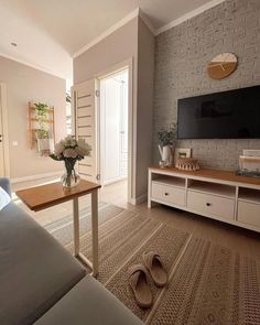 a living room filled with furniture and a flat screen tv on top of a wooden table