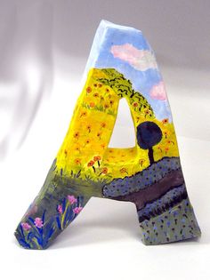 a painted wooden letter sitting on top of a white table