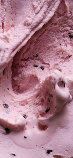 a scoop of ice cream with chocolate chips on top and pink icing in the middle