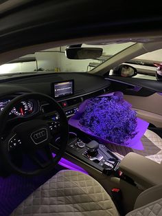 the interior of a car with purple lights and leather seats, including an automatic steering wheel