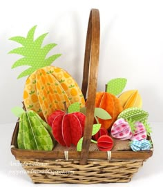 a basket filled with lots of different types of paper fruits and vegetables on top of each other