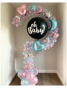 a balloon arch that says oh baby surrounded by balloons in pastel blue, pink and white colors