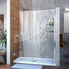 a bathroom scene with focus on the shower and bathtub, rugs and towels