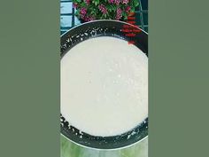 a pan filled with food sitting on top of a table next to a potted plant