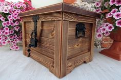 a wooden box sitting in front of some flowers