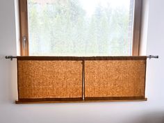 a window with two brown blinds in front of it