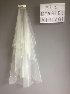 a wedding veil hanging on the wall next to a sign that says me and my girl vintage