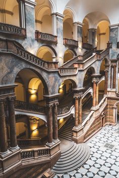 the interior of a building with many stairs and arches on each side, leading up to an upper floor