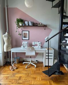 a white desk sitting under a stair case next to a wall filled with shelves and pictures