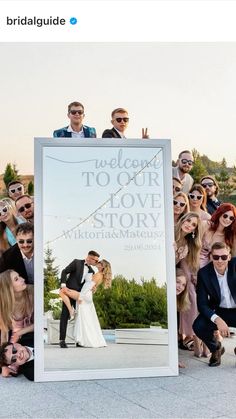 a large group of people are posing for a photo with a sign that says welcome to our love story