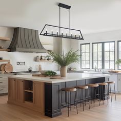 a large kitchen with an island and bar stools next to the stove top oven