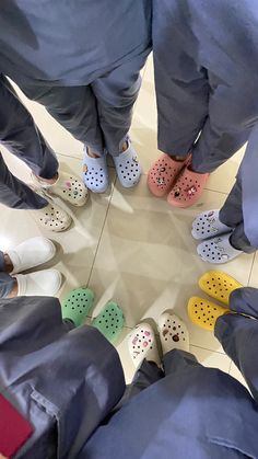 several doctors standing in a circle with their feet on each other's ankles wearing crocs