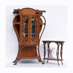 an old fashioned wooden china cabinet next to a small table