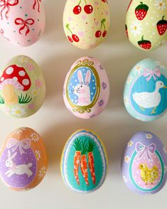 an assortment of painted eggs on a white surface