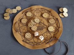 a wooden board game with dices and coins on the table next to some cords