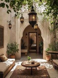 a living room with couches, tables and hanging lights on the wall next to an archway