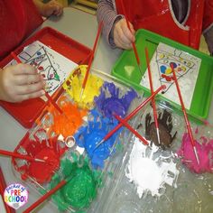 two children are working on crafts at a table with plastic trays and colored sticks