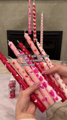 a woman is holding candles with hearts on them