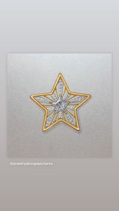 an image of a star brooch in gold and white with diamonds on the side