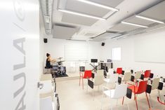 a room filled with lots of white and red chairs