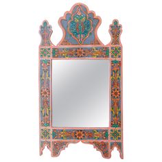 an ornately painted mirror is shown against a white background