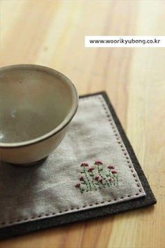 a white bowl sitting on top of a wooden table next to a small cup holder