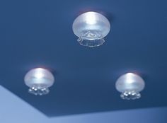 three lights are hanging from the ceiling in a room with blue walls and flooring