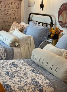 two beds with blue and white comforters in a bedroom next to a wall mounted typewriter