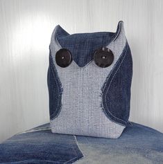 an owl made out of jeans with buttons on it's eyes sitting on top of a chair