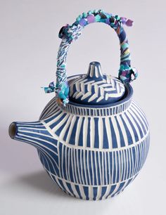 a blue and white tea pot with a handle