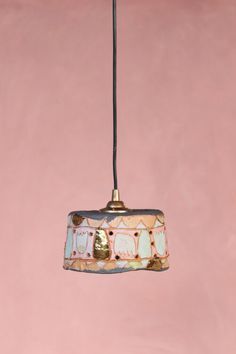 a light fixture hanging from a pink wall