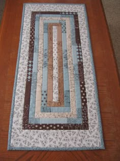 a wooden table with a blue and brown quilt on it