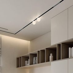 a room with white walls and shelves filled with books