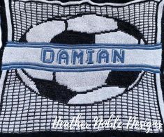 a close up of a soccer ball on a pillow with the word damn in blue and white