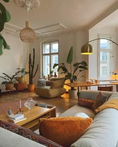 a living room filled with lots of furniture and plants