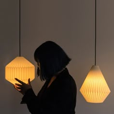 a woman is holding two lamps in her hands