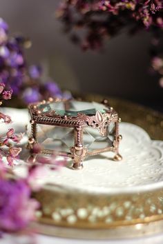 a close up of a cake on a plate with purple flowers in the back ground