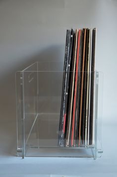 a stack of vinyl records in a clear acrylic case on a white background