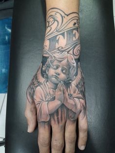 a person's hand with an angel tattoo on it