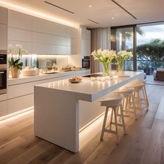 a modern kitchen with white cabinets and counter tops is lit by recessed lighting that illuminates natural light