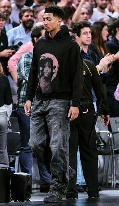 a man standing on top of a skateboard in front of a crowd