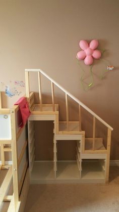 there is a room with some stairs and pink balloons on the wall above it,