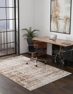 an office area with a rug, desk and chair in it's centerpiece